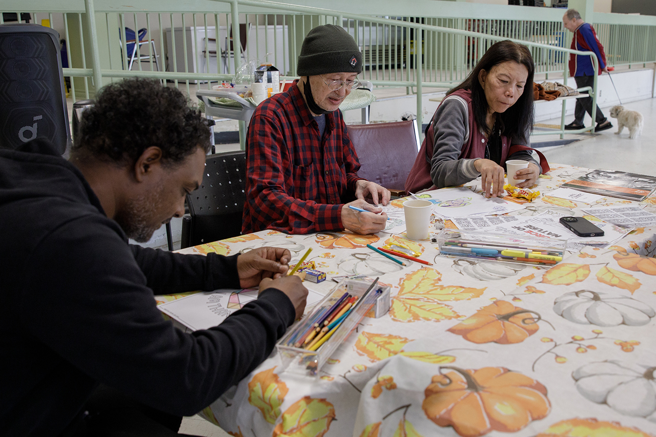 Three people do art at a table