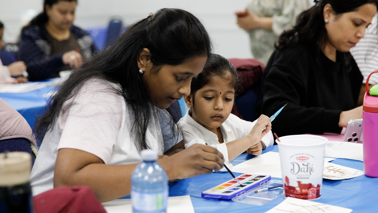 A woman helps her young daughter paint at a Seeds for Change Watercolour Workshop in Cooksville