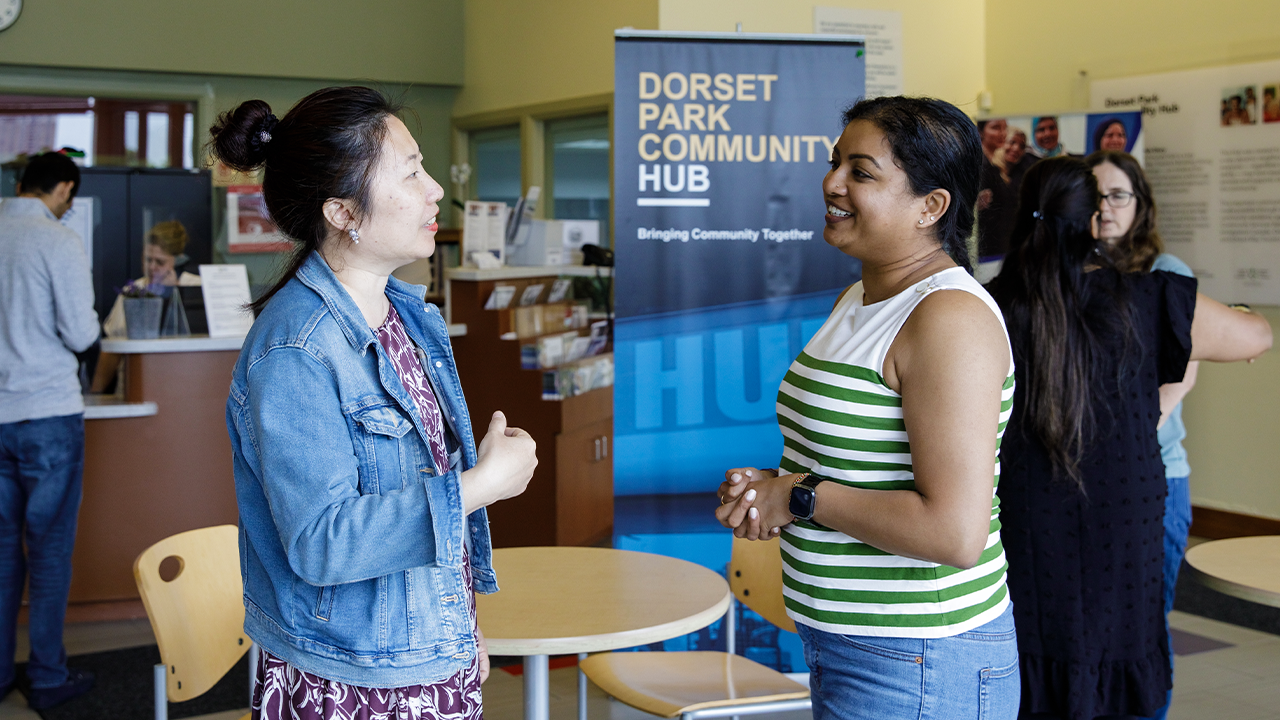 Emily talks with another community member in a gathering space at the Dorset Park Community Hub.