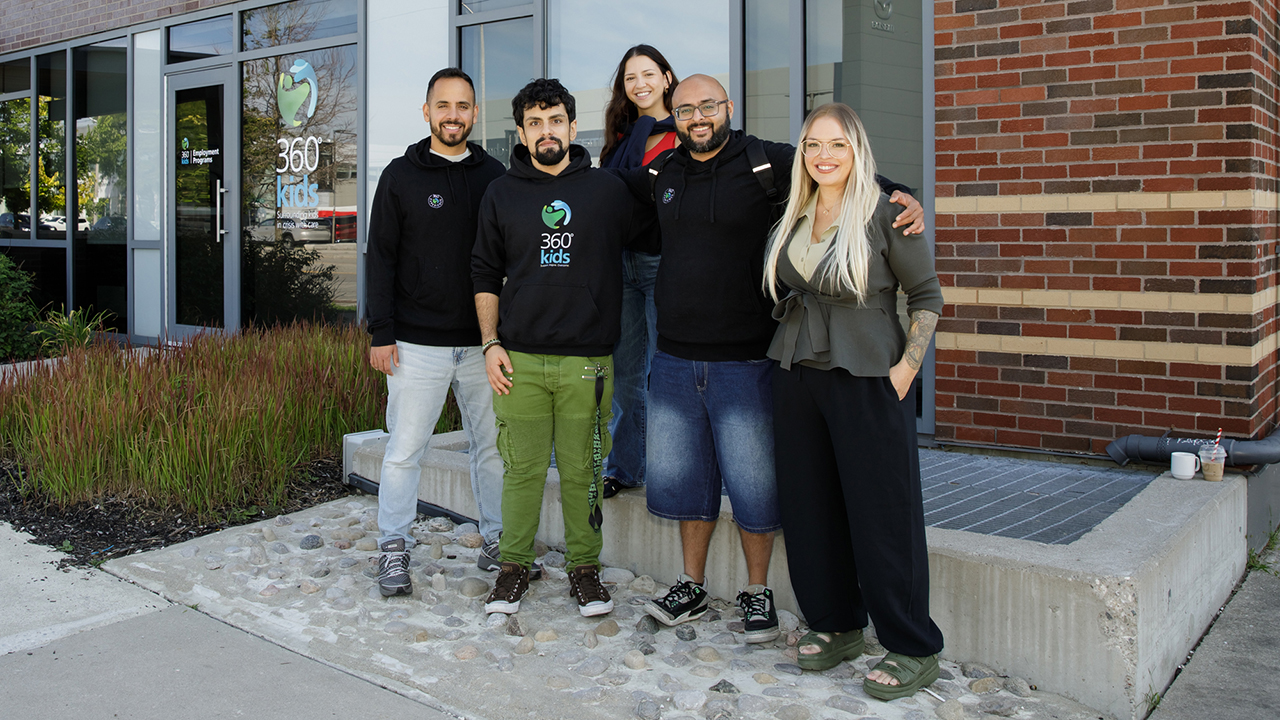 A group photo 360°kids support staff standing in front of their building, smiling.