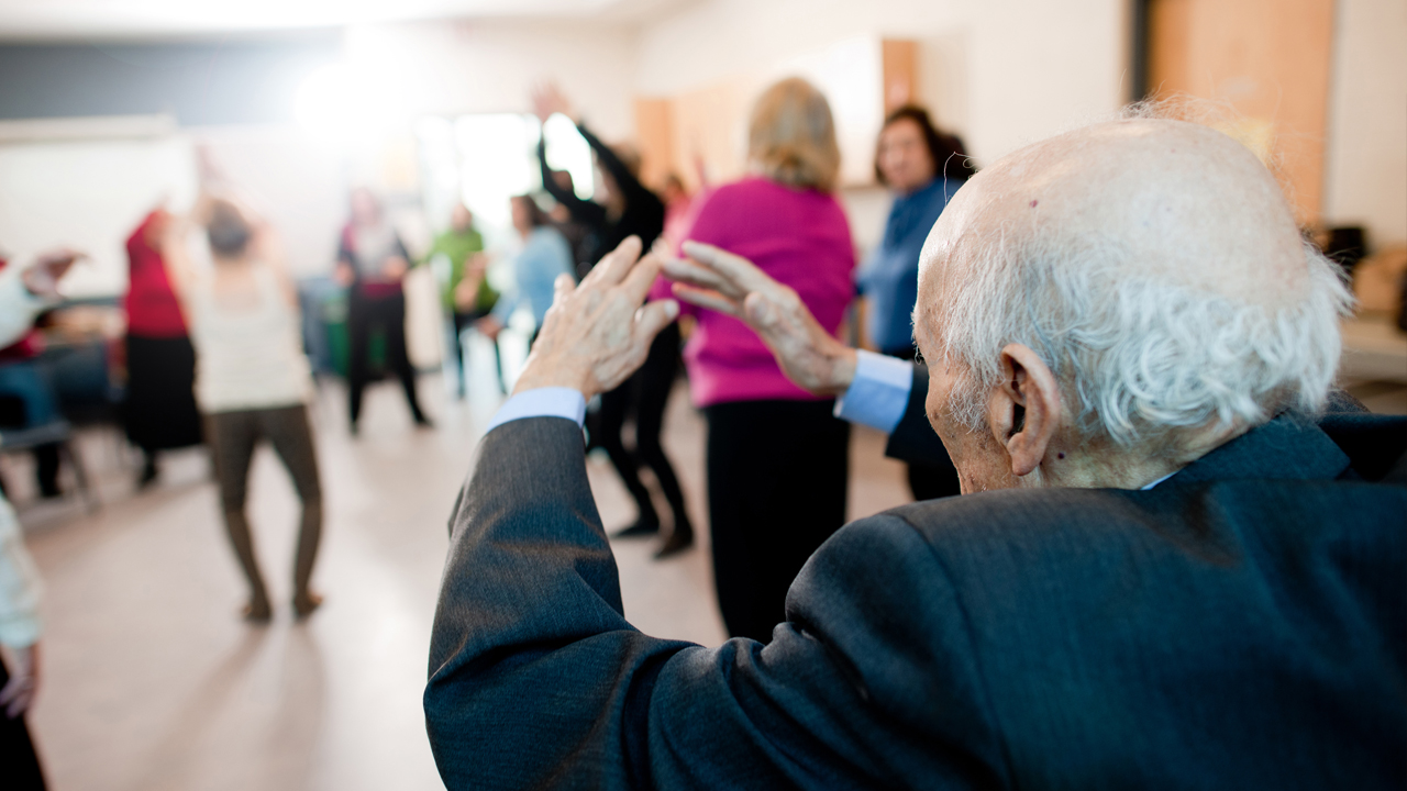 Senior man puts his hands up during a group exercise