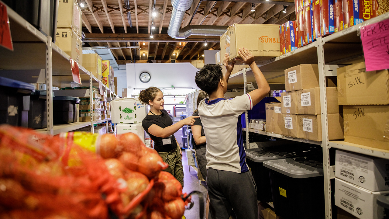 People stacking boxes of food in a warehouse