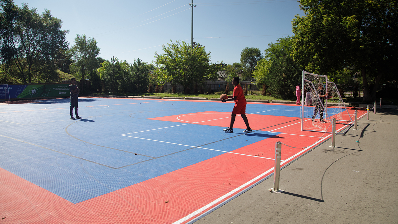 Kids play with a basketball on an outdoor sports court